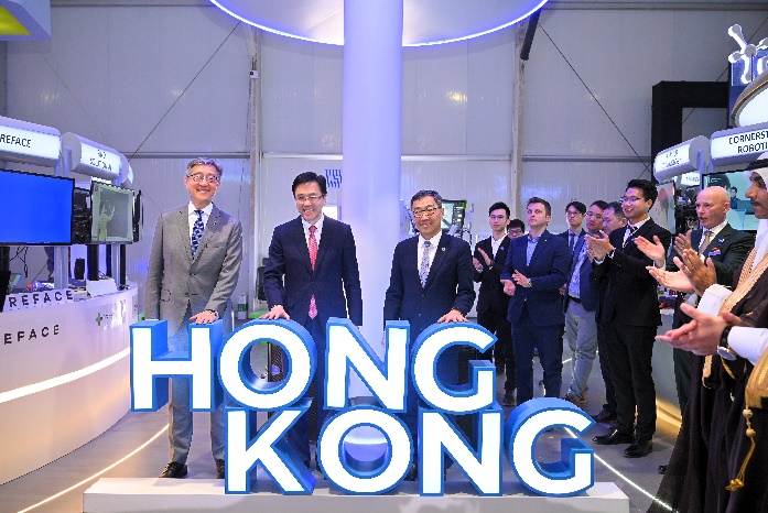 A group of men standing in front of a sign Description automatically generated